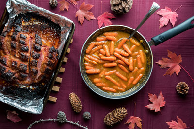 Top down view of a smoked picnic ham along with sauteed candied carrots.