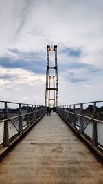 People walking on bridge against sky