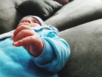 Close-up of baby boy relaxing on sofa at home