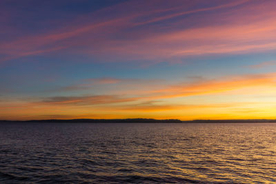 Scenic view of sea against dramatic sky during sunset