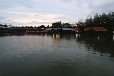 Houses by lake against sky