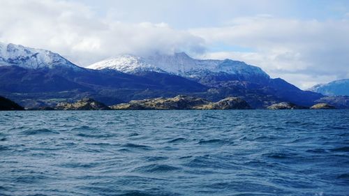 Scenic view of sea and mountains against sky