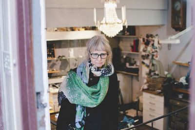 Senior female owner wearing scarf in jewelry store