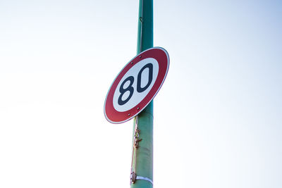 Low angle view of road sign against clear sky