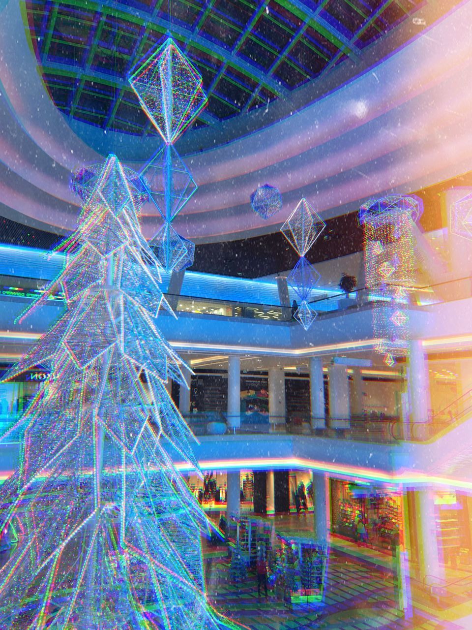 DIGITAL COMPOSITE IMAGE OF ILLUMINATED FERRIS WHEEL IN BUILDING AT NIGHT