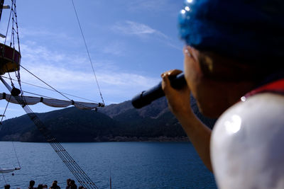 Midsection of person sailing on sea against sky