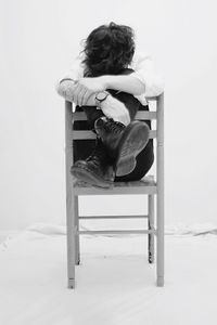 Boy sitting on chair at home