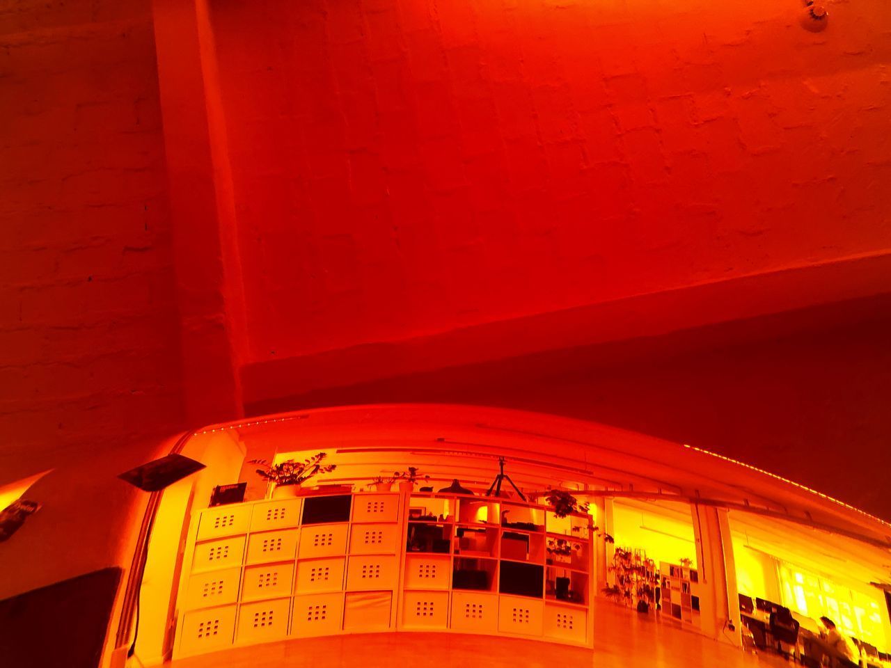 LOW ANGLE VIEW OF ILLUMINATED BUILDING IN ORANGE WALL