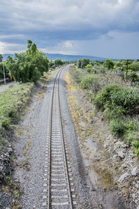 Railroad track amidst trees against sky