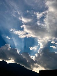 Low angle view of silhouette mountain against dramatic sky