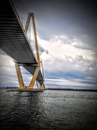 Low angle view of suspension bridge over sea