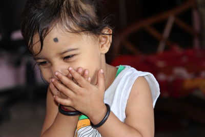 Close-up of girl covering mouth while laughing