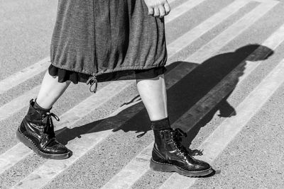 Low section of woman walking on crosswalk