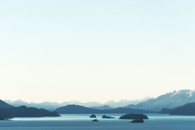 Scenic view of sea and mountains against clear sky simulating a painting