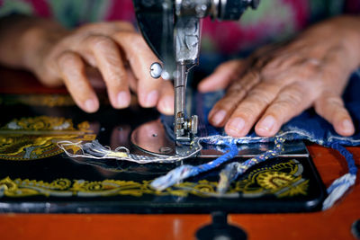 Cropped image of woman using sewing machine