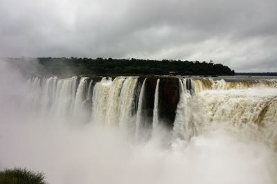 Scenic view of waterfall against sky