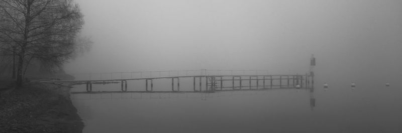 Bridge over river in foggy weather