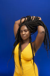 Young woman wearing colorful long clothes over blue background. natural expression.