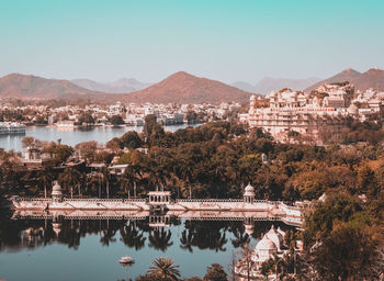 Scenic view of river by buildings against clear sky