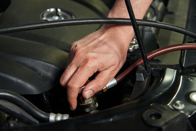 Hands of the master in cars and various car parts. car engine, bumper, metal parts of the car.