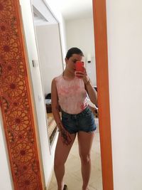 Full length of young woman using mobile phone