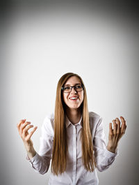 Portrait of smiling young woman against white background