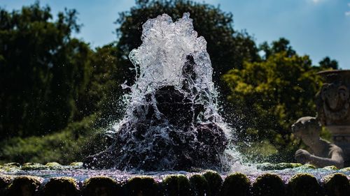 Water splashing in fountain against sky