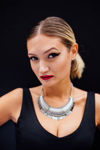 Portrait of beautiful model standing against black background