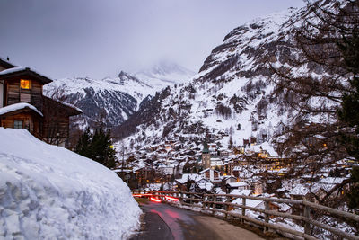 Road by snow covered mountain against sky