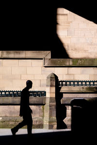 Side view of silhouette man standing against wall