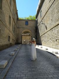 Rear view of woman standing by building