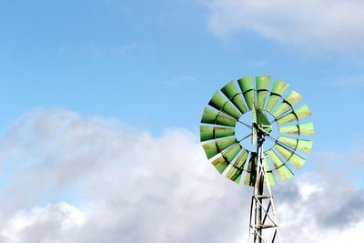 Green windmill with blue sky and clouds