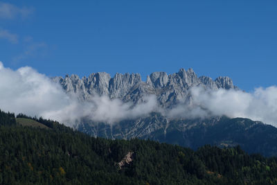 Low angle view of majestic mountains against blue sky