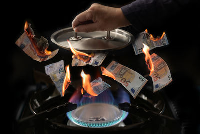 Cropped hand of man preparing food at night