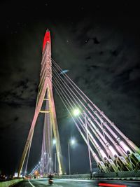 Low angle view of illuminated bridge against sky at night