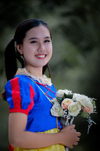 Portrait of young woman holding bouquet