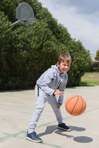 Boy playing with basketball at park