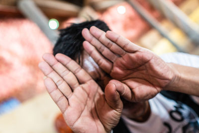 Close-up of man hiding face outdoors