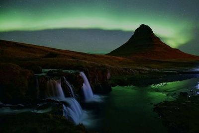 Scenic view of waterfall against sky at night