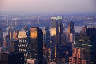 Aerial view of city lit up against the sky