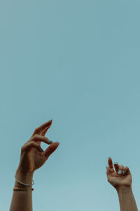 Close-up of human hand against clear sky