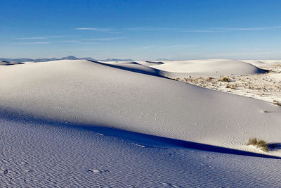 Scenic view of snow covered landscape against blue sky