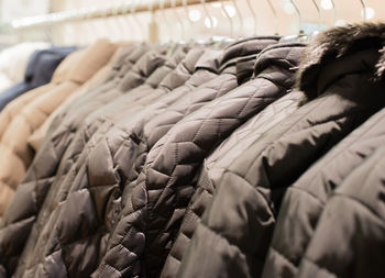 Close-up of multi colored clothes hanging in rack for sale