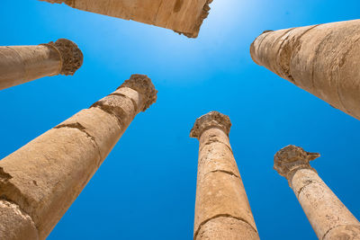 Low angle view of old ruins against blue sky