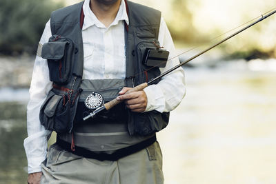 Man holding camera while standing outdoors