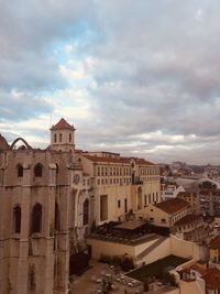 High angle view of buildings in city against cloudy sky