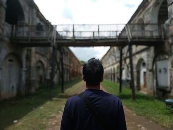 Rear view of man standing on bridge