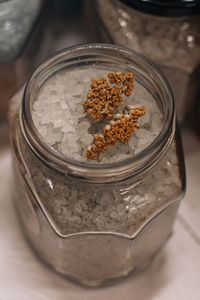 Glass jar with natural gray bath salt with dry flower. spa and beauty concept