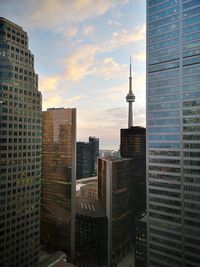 Modern buildings in city against sky during sunset