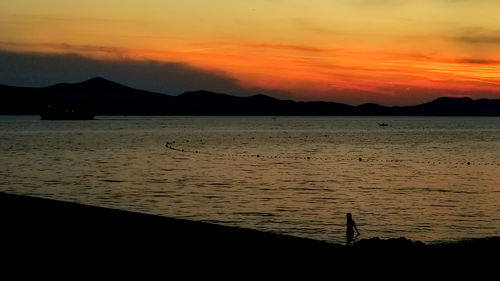 Scenic view of sea against orange sky